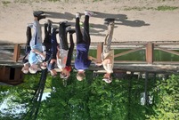 grupa dzieci przy ogrodzeniu w oddali staw